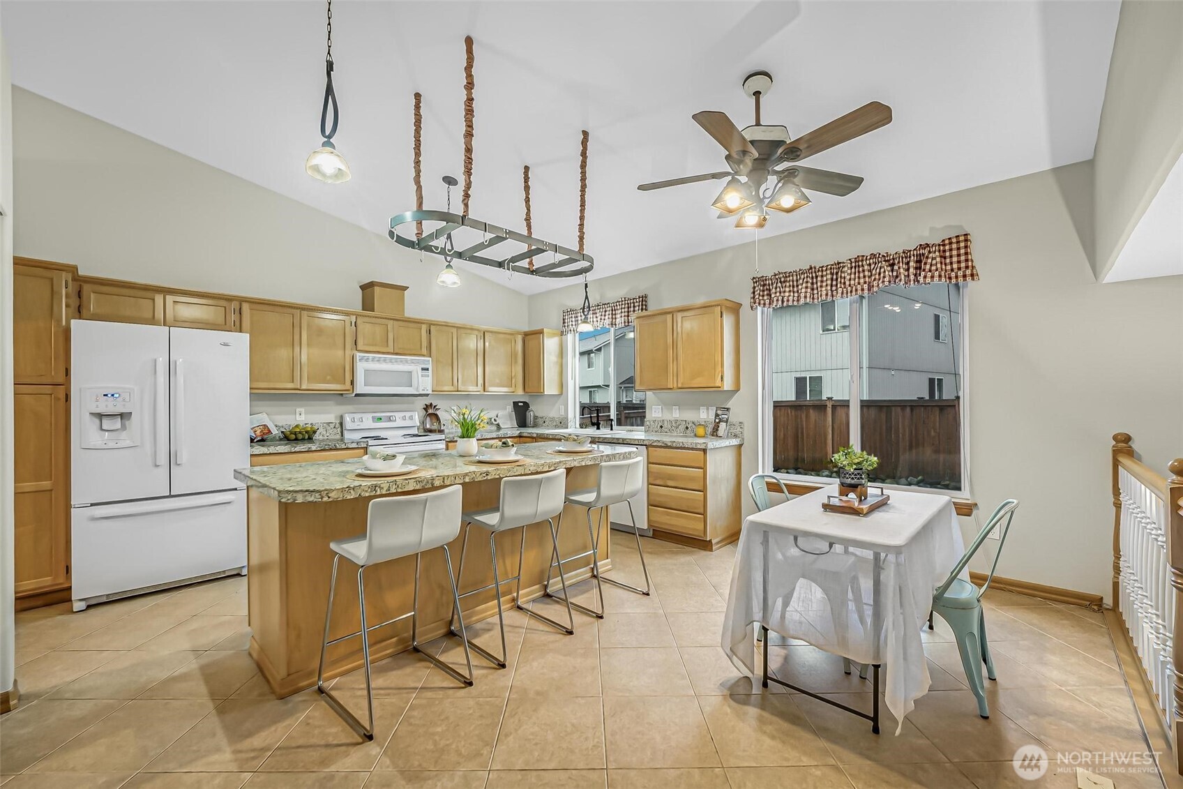 21012 Springhaven Way East Bonney Lake, WA 98391 - Photo 14 of 39 a kitchen with stainless steel appliances kitchen island granite countertop a sink a stove a dining table and chairs