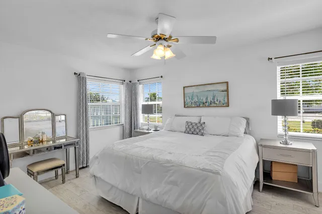 a bedroom with a bed and a large window with a chandelier