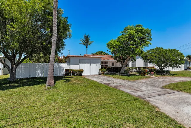a view of a house with backyard and tree