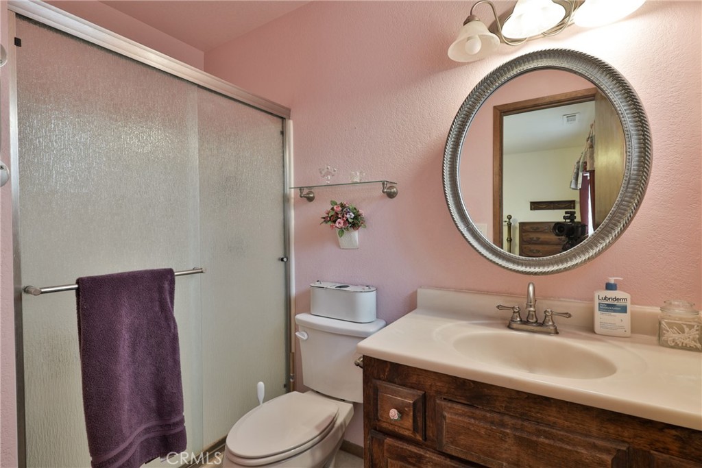 39177 Arapahoe Road Fawnskin, CA 92333 - Photo 21 of 39 a bathroom with a sink a toilet and a mirror