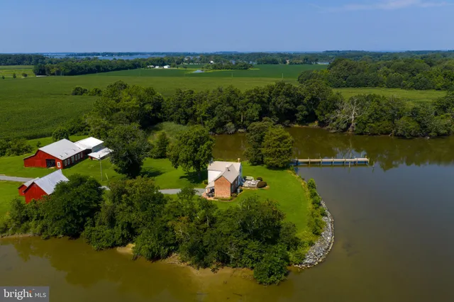 an aerial view of a house with a yard and lake view