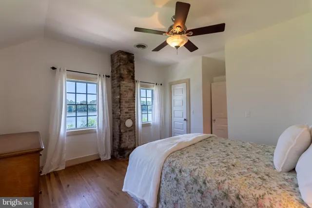 a bedroom with a large bed chandelier and a window