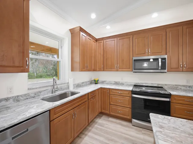 a kitchen with granite countertop a sink and refrigerator