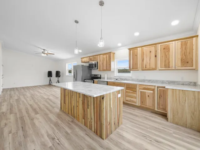 an empty room with a window and a ceiling fan