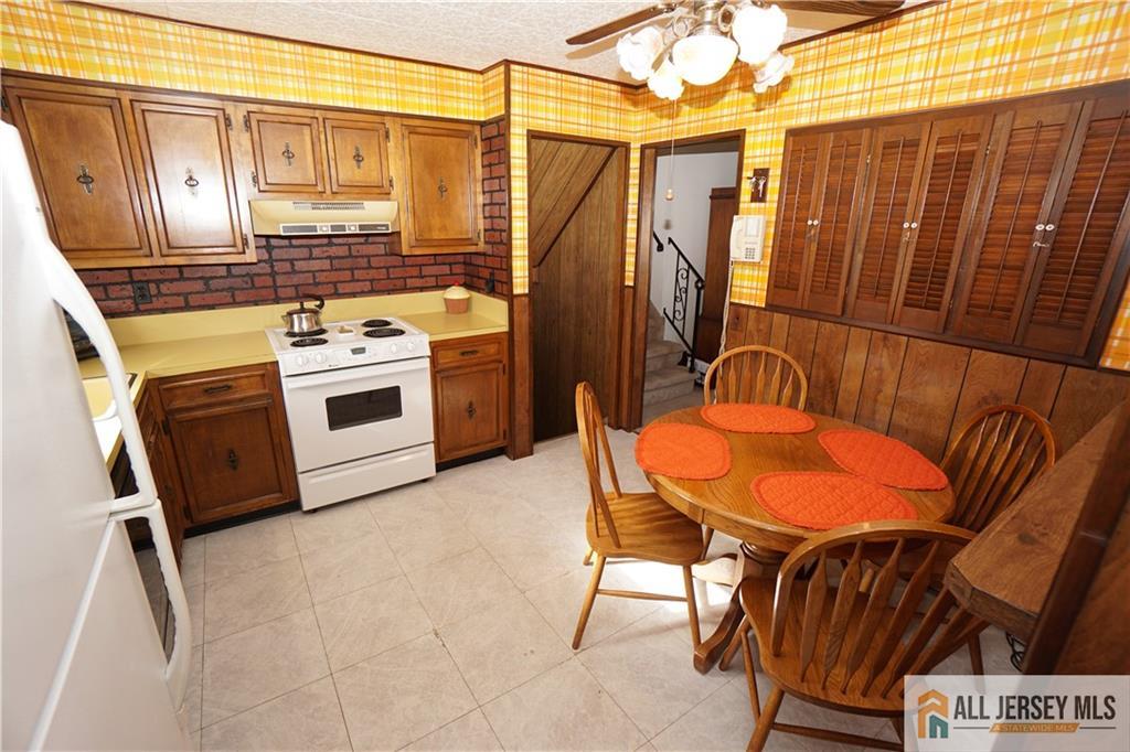 32 Predmore Avenue Colonia, NJ 07067 - Photo 11 of 28 a kitchen with stainless steel appliances a stove a refrigerator and furniture