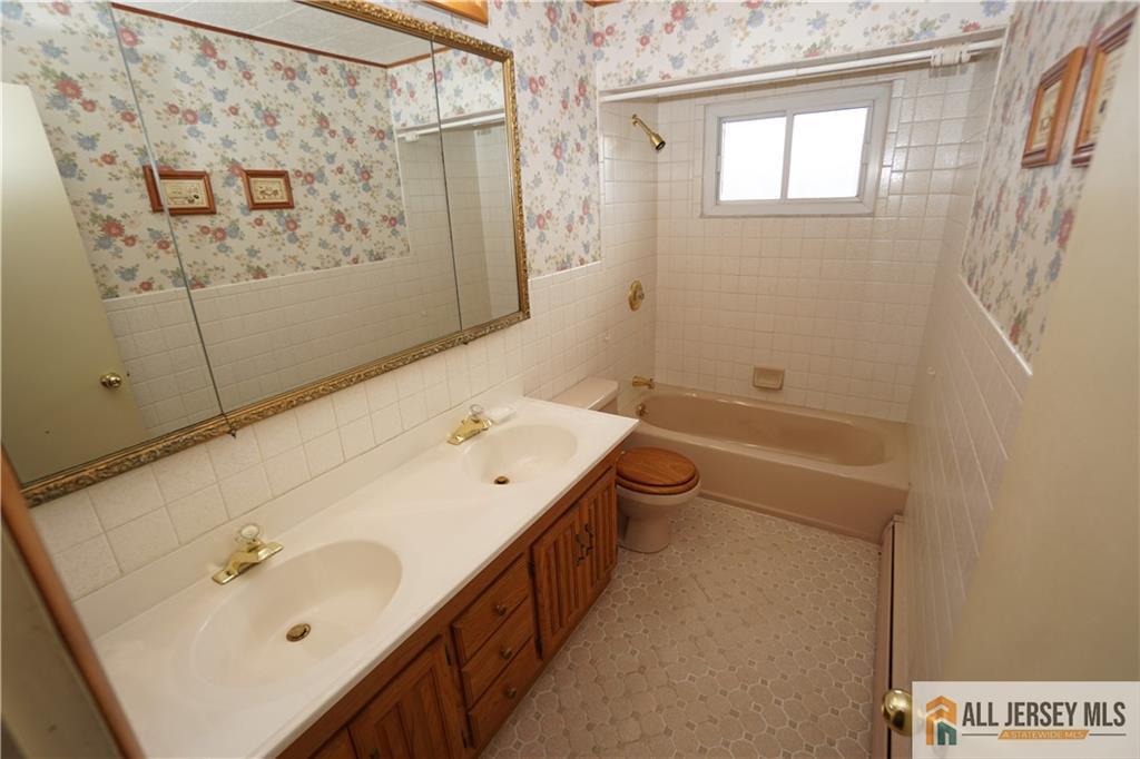 32 Predmore Avenue Colonia, NJ 07067 - Photo 16 of 28 a bathroom with a tub sink and mirror