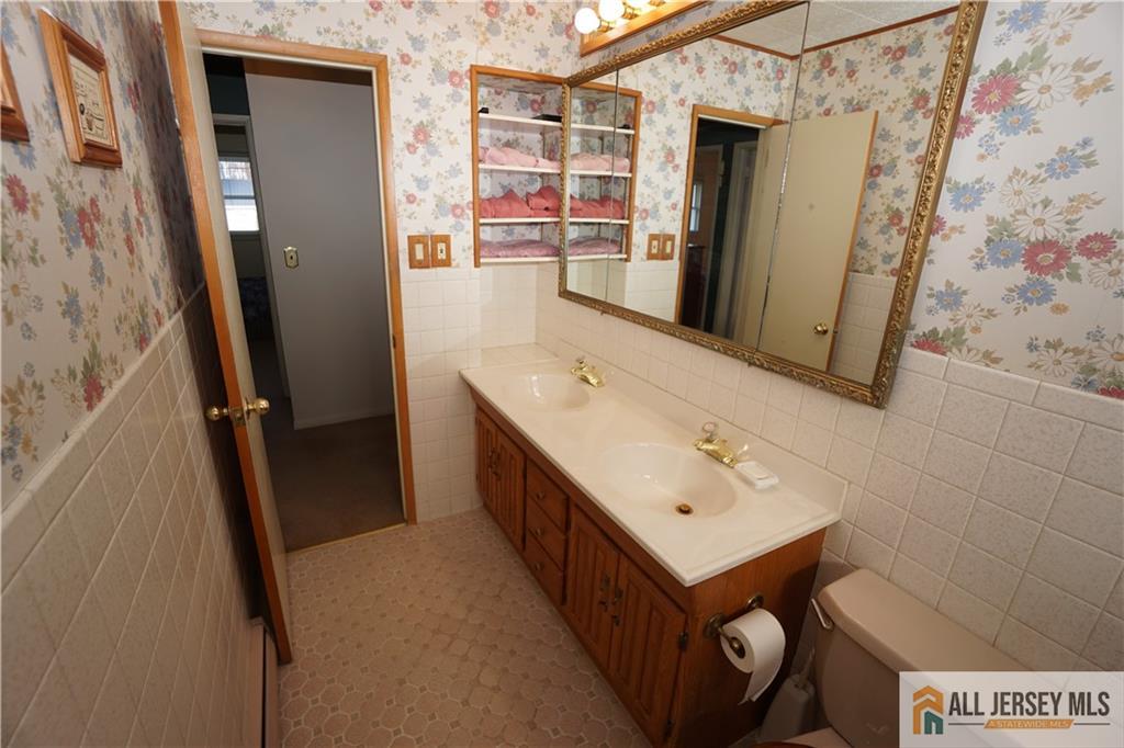 32 Predmore Avenue Colonia, NJ 07067 - Photo 17 of 28 a bathroom with a sink a mirror and a shower