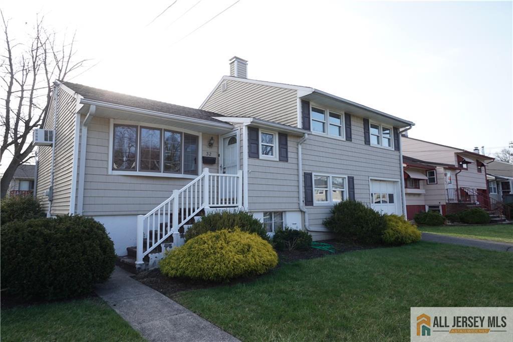 32 Predmore Avenue Colonia, NJ 07067 - Photo 3 of 28 a brick house with a small yard and plants