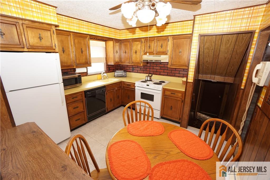 32 Predmore Avenue Colonia, NJ 07067 - Photo 9 of 28 a kitchen with stainless steel appliances kitchen island granite countertop a refrigerator a stove a sink dishwasher with a dining table and chairs