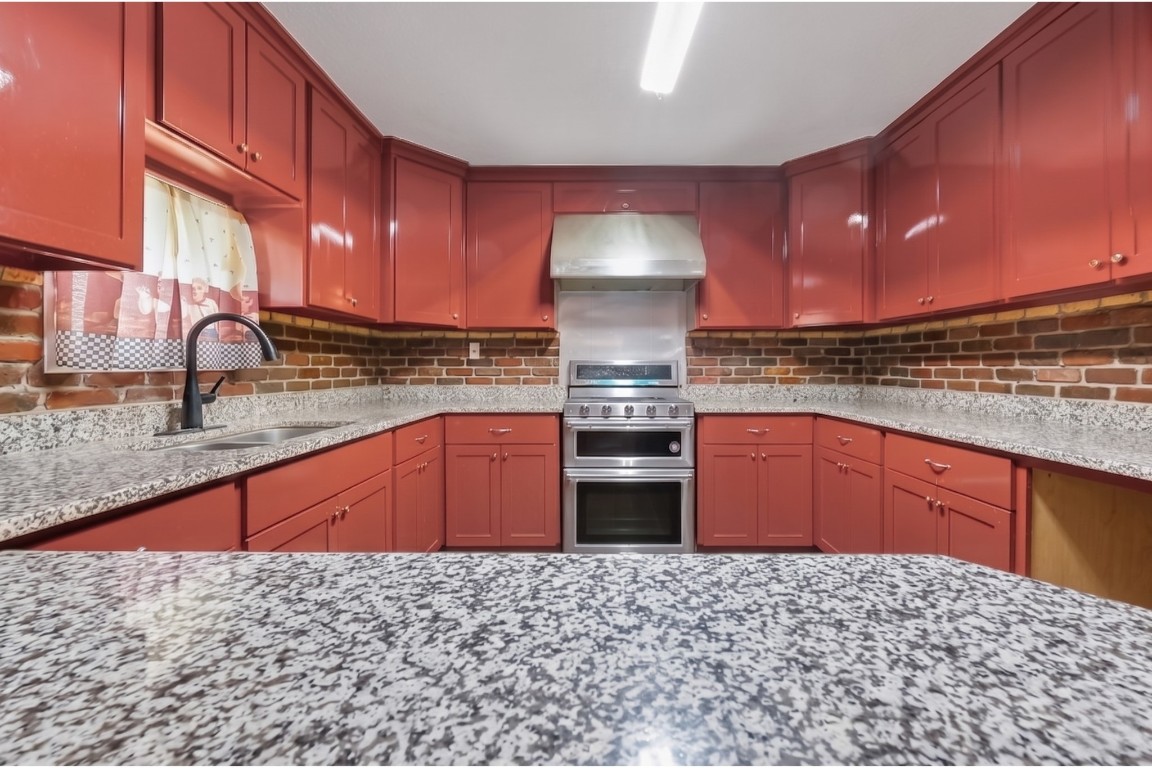 6014 Linda Drive Rosharon, TX 77583 - Photo 11 of 23 Centered around a high-quality stainless steel range and vent hood, the space offers plenty of storage within the seamless wrap-around cabinetry.
