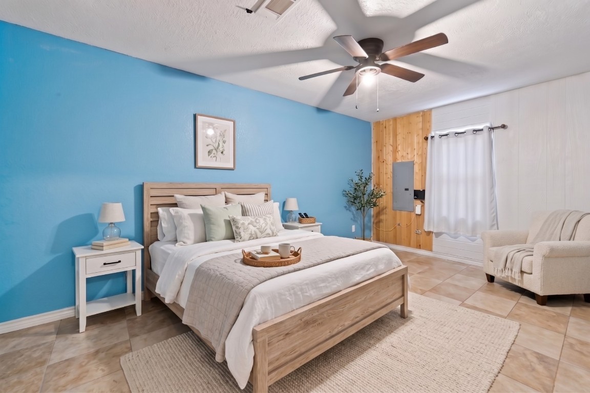 6014 Linda Drive Rosharon, TX 77583 - Photo 16 of 23 This secondary bedroom features a checker-pattern tile flooring, a ceiling fan, and a striking blue accent wall.**Virtually staged
