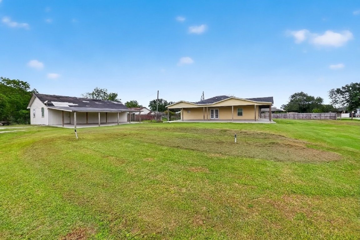 6014 Linda Drive Rosharon, TX 77583 - Photo 21 of 23 This wide-angle shot showcases the primary residence alongside a substantial detached workshop on the oversized lot.
