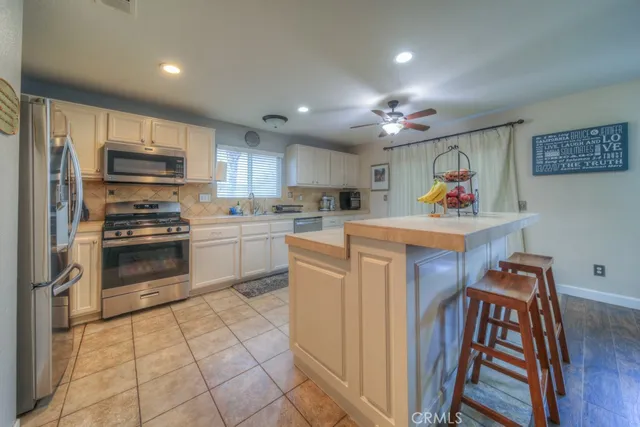 a kitchen with granite countertop a sink appliances cabinets and a counter top space