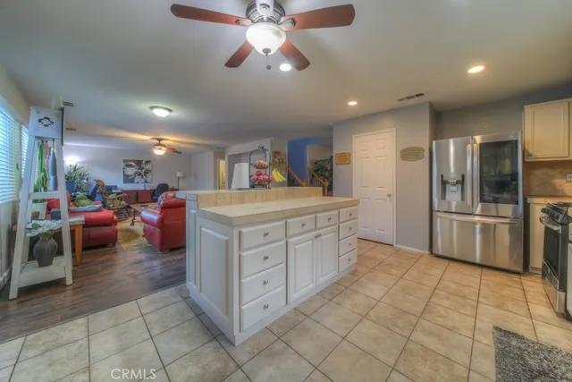 a kitchen with stainless steel appliances kitchen island granite countertop a refrigerator and a sink
