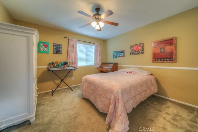 a spacious bedroom with a bed and a ceiling fan