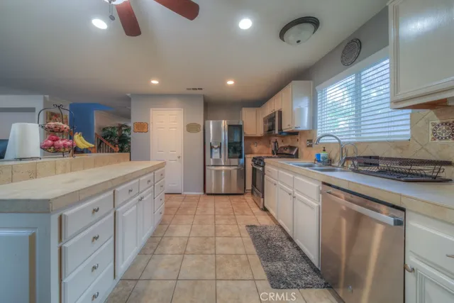 a large kitchen with stainless steel appliances lots of counter space sink refrigerator and cabinets
