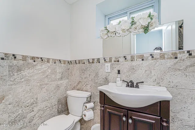 a bathroom with a sink a toilet and a mirror