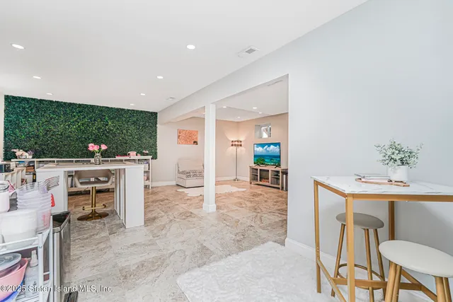 a living room with furniture a flat screen tv and a floor to ceiling window