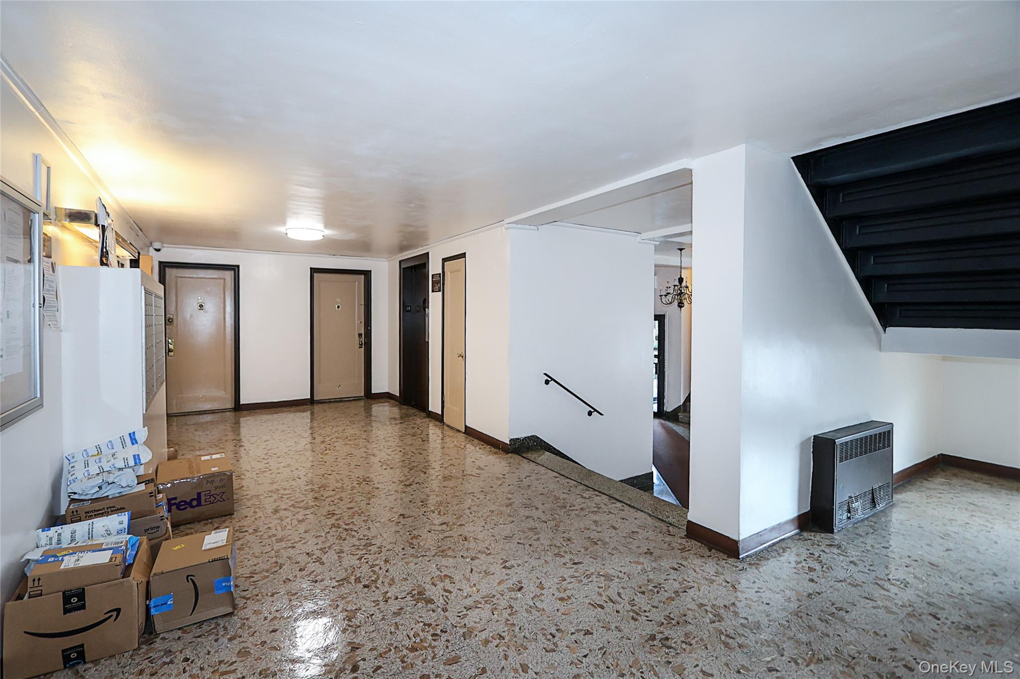 147-10 84th Road, Unit 6K Queens, NY 11435 - Photo 20 of 21 Unfurnished living room featuring heating unit, a chandelier, and speckle patterned floor