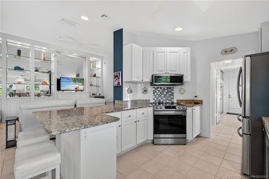 1035 Southwest Tamarrow Place Stuart, FL 34997 - Photo 6 of 46 Breakfast bar makes entertaining a breeze