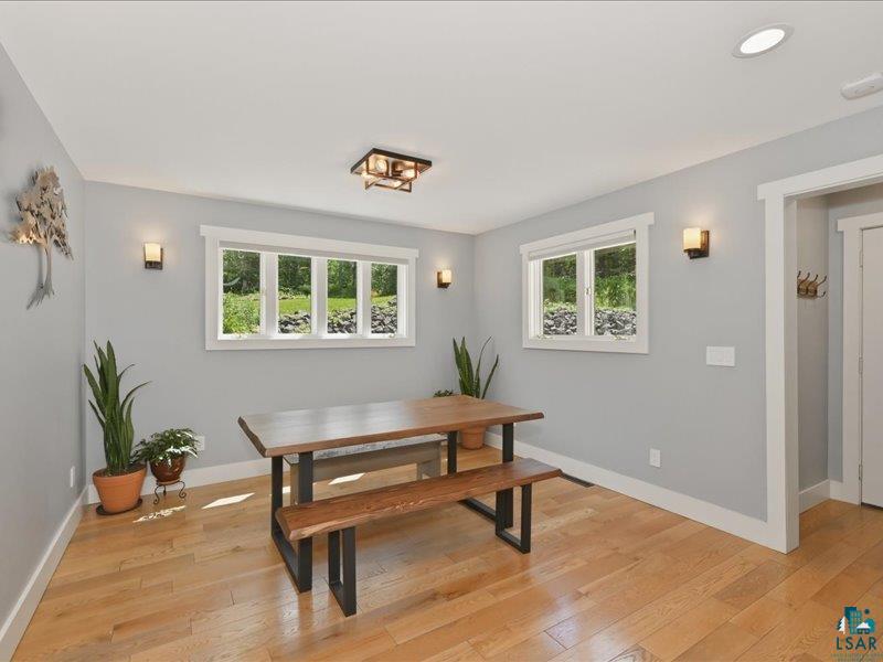 88440 Huron Street Cornucopia, WI 54827 - Photo 13 of 44 Light-filled dining area featuring wood-finish flooring, two large windows with white trim, and recessed ceiling lighting