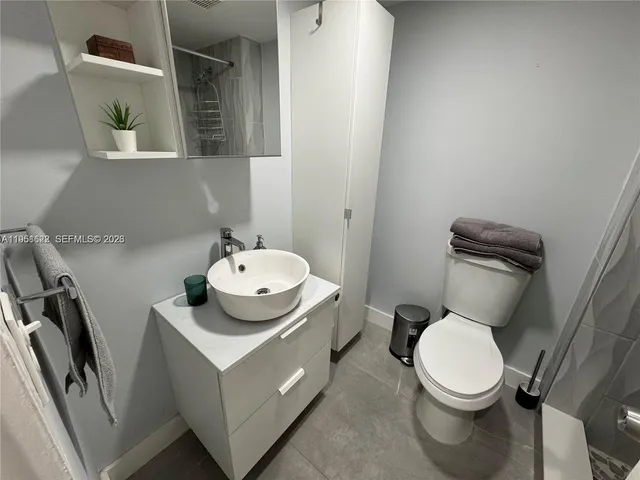 a white toilet sitting next to a bathroom sink