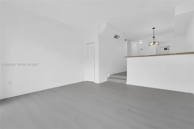 a view of an empty room with kitchen