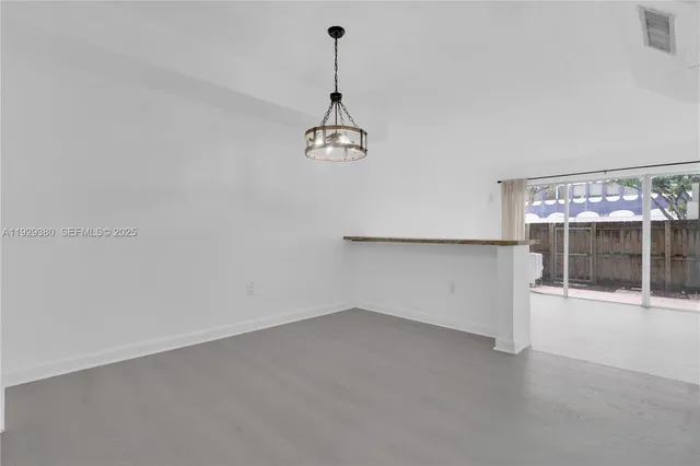 an empty room with chandelier fan