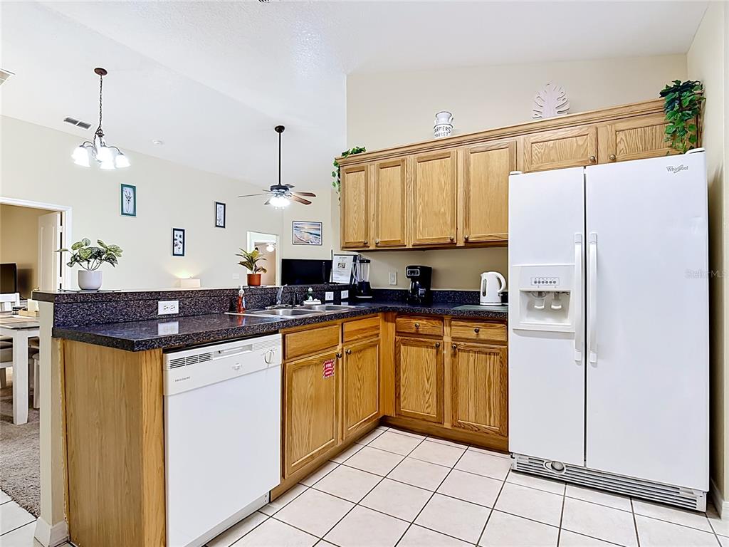 522 Sandy Ridge Drive Davenport, FL 33896 - Photo 13 of 34 a kitchen with stainless steel appliances granite countertop a refrigerator and a stove top oven