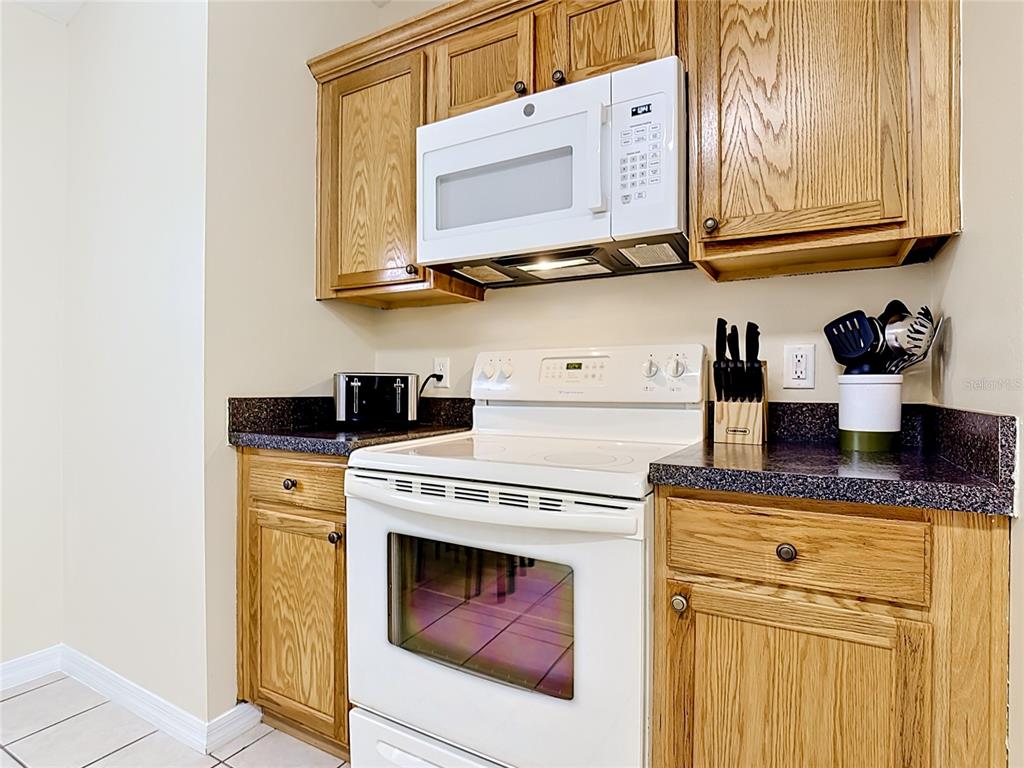 522 Sandy Ridge Drive Davenport, FL 33896 - Photo 14 of 34 a kitchen with stainless steel appliances granite countertop a sink a stove and cabinets