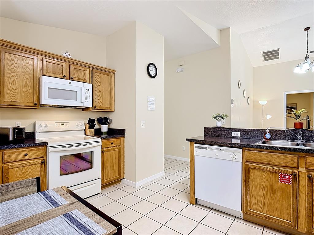 522 Sandy Ridge Drive Davenport, FL 33896 - Photo 15 of 34 a kitchen with stainless steel appliances granite countertop a stove a sink and a refrigerator