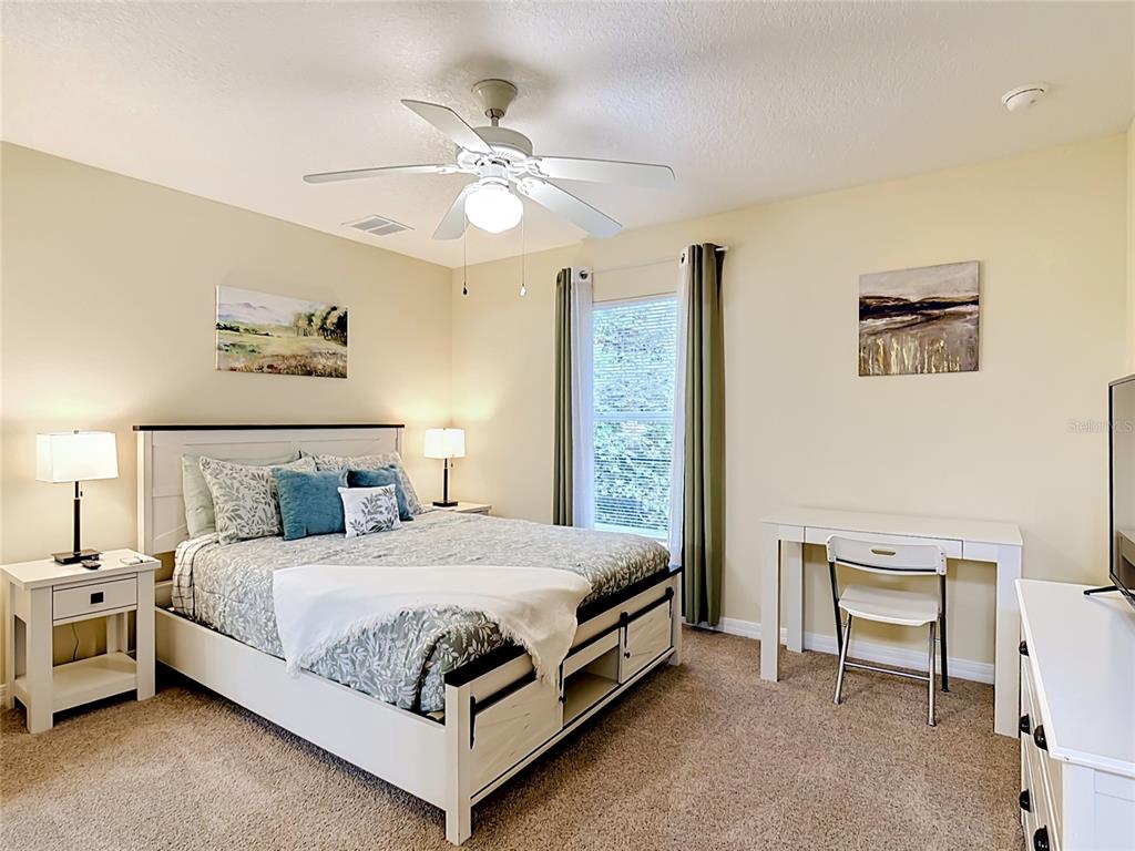 522 Sandy Ridge Drive Davenport, FL 33896 - Photo 20 of 34 a bedroom with a bed and a chandelier