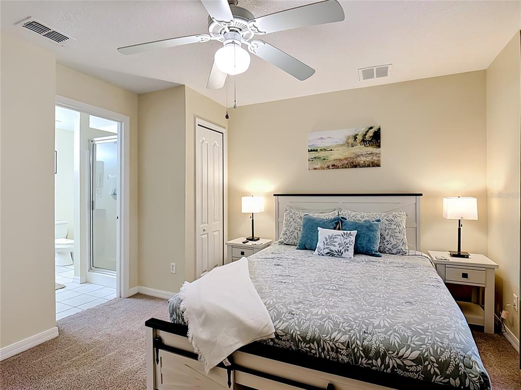 522 Sandy Ridge Drive Davenport, FL 33896 - Photo 21 of 34 a bedroom with a bed and a chandelier