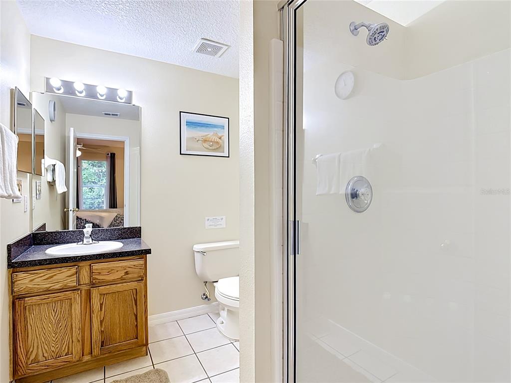 522 Sandy Ridge Drive Davenport, FL 33896 - Photo 22 of 34 a bathroom with a granite countertop sink toilet and shower