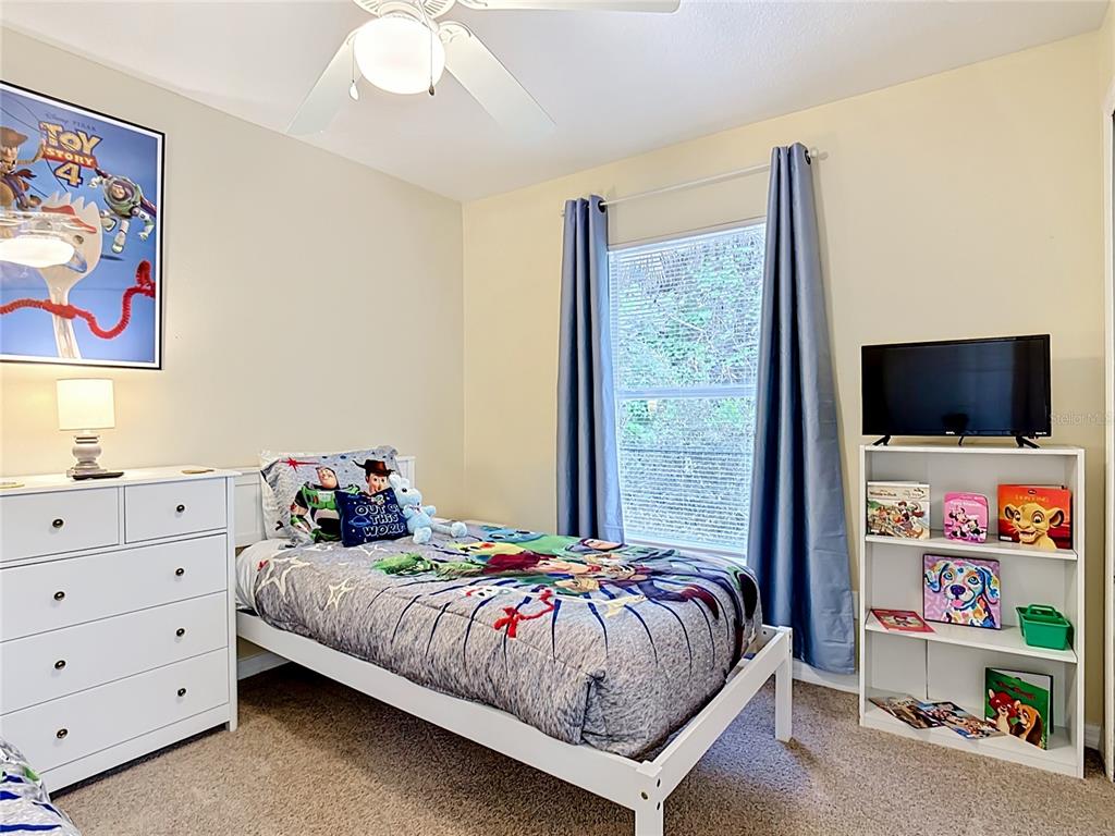 522 Sandy Ridge Drive Davenport, FL 33896 - Photo 26 of 34 a bedroom with a bed and a flat screen tv