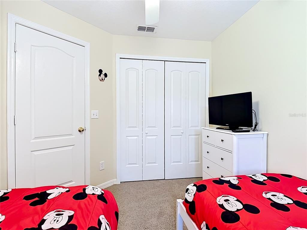522 Sandy Ridge Drive Davenport, FL 33896 - Photo 29 of 34 a bedroom with a bed and a flat screen tv