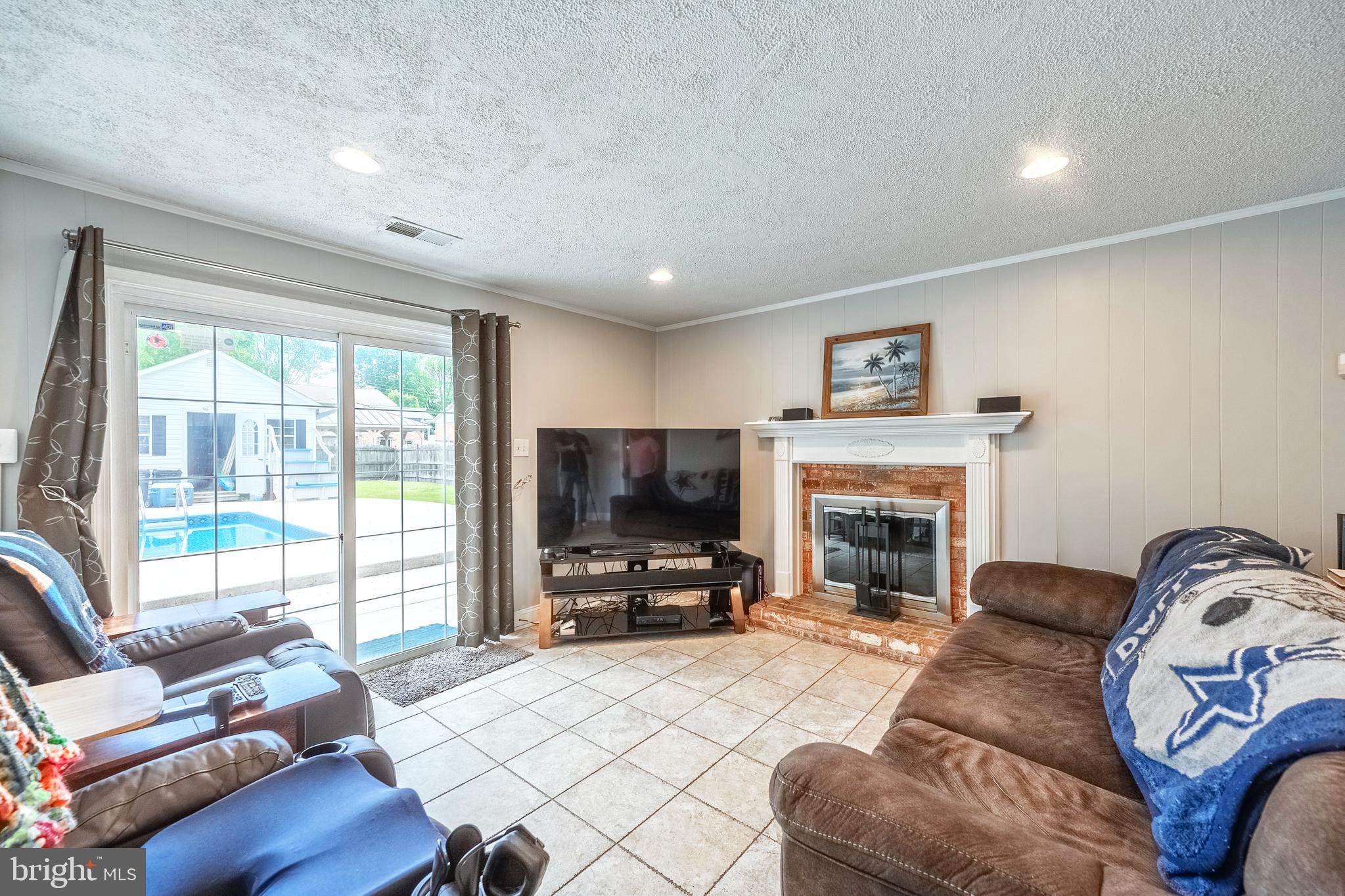 9722 Copeland Drive Manassas, VA 20109 - Photo 29 of 46 a living room with furniture a fireplace and a flat screen tv