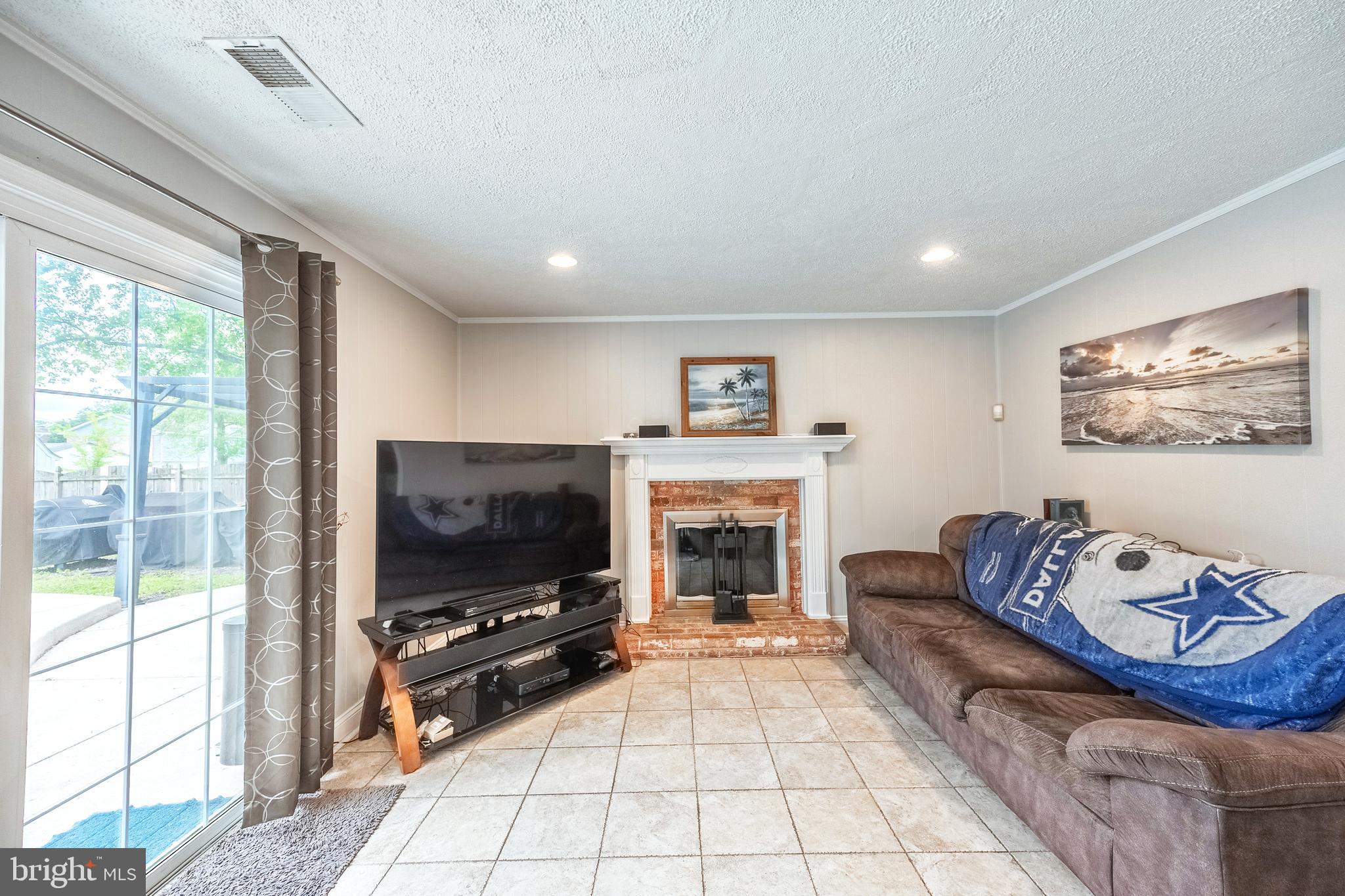 9722 Copeland Drive Manassas, VA 20109 - Photo 30 of 46 a living room with furniture a flat screen tv and a fireplace