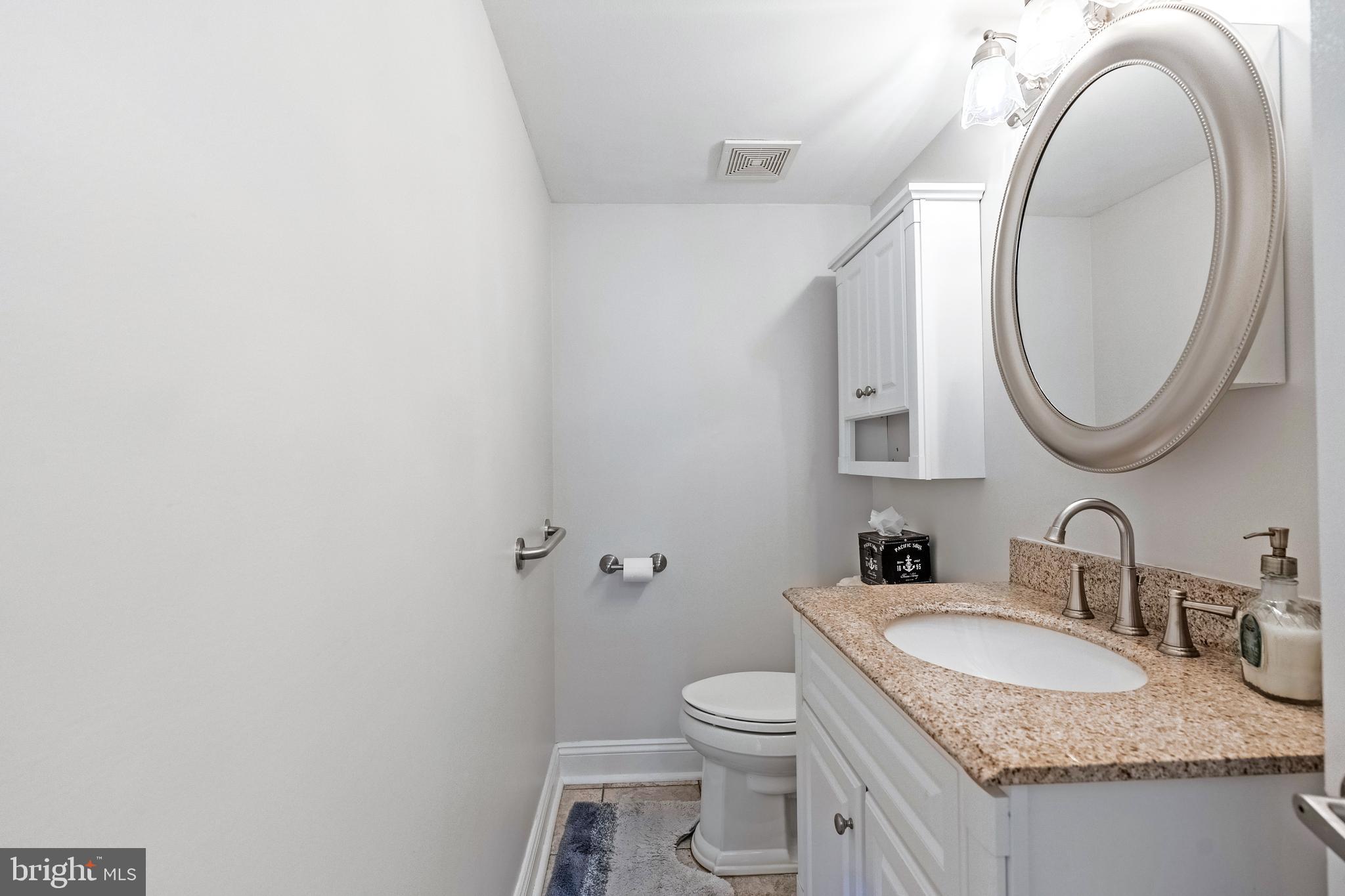 9722 Copeland Drive Manassas, VA 20109 - Photo 34 of 46 a bathroom with a granite countertop toilet a sink and a mirror