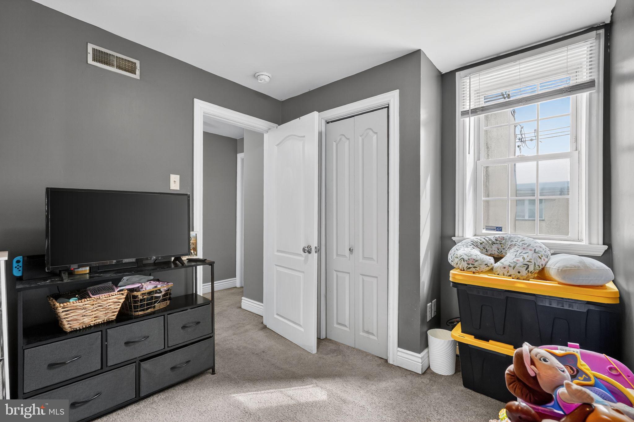 2907 South Sydenham Street Philadelphia, PA 19145 - Photo 8 of 15 a bedroom with furniture and a flat screen tv