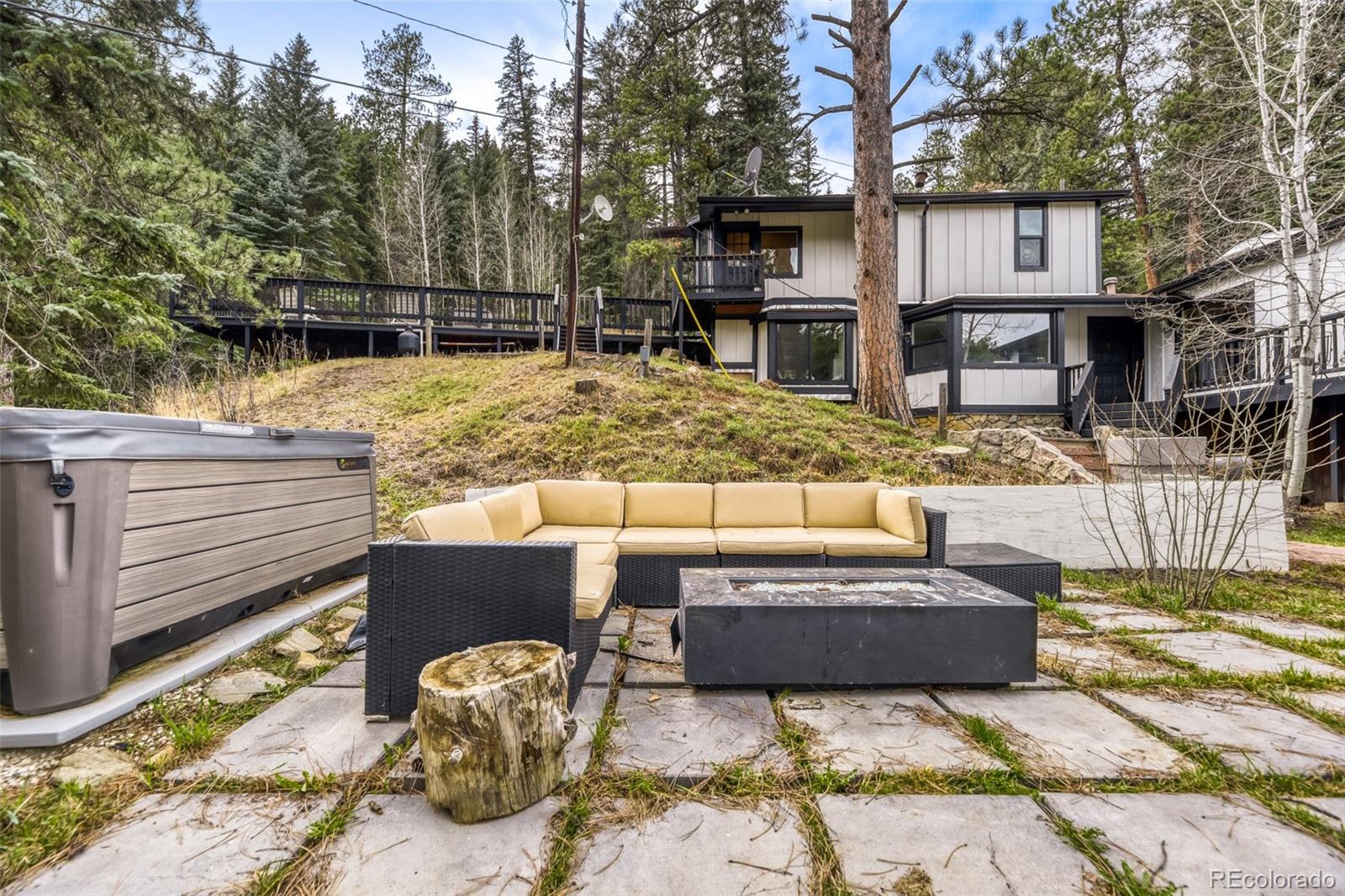 7489 South Turkey Creek Road Morrison, CO 80465 - Photo 25 of 28 a view of a patio with couches table and chairs with wooden floor and fence