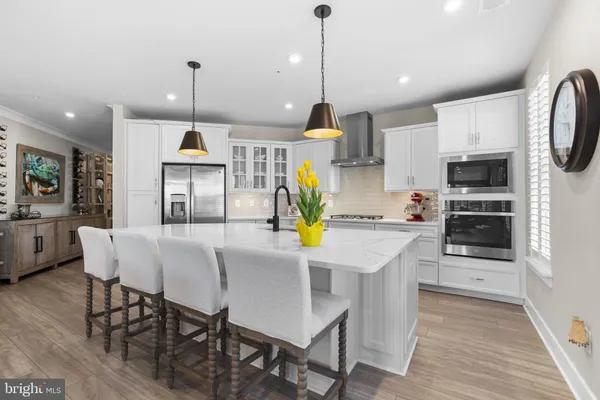 a kitchen with stainless steel appliances kitchen island granite countertop a table chairs and a refrigerator