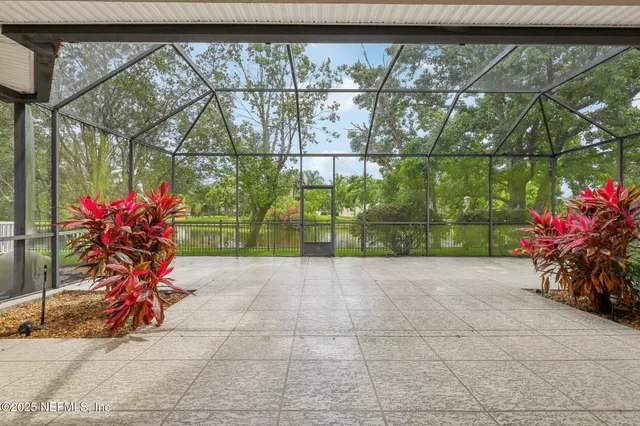 a view of a yard in front of a house with plants and large tree
