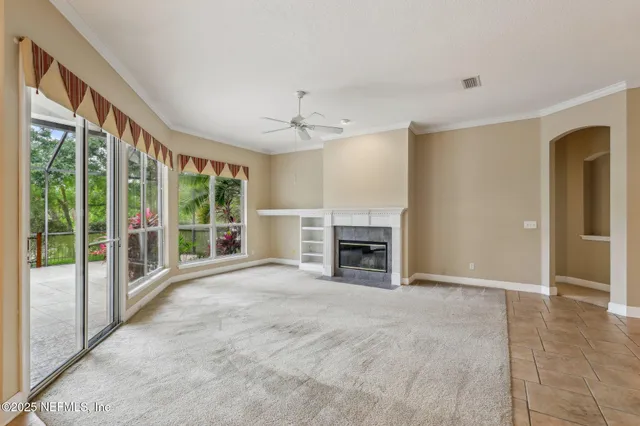 a view of an empty room with a fireplace and a window