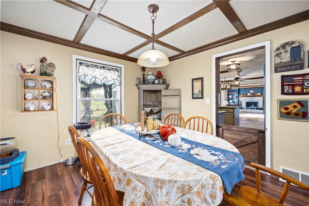 41511 Russia Road Elyria, OH 44035 - Photo 12 of 33 Dining space featuring dark hardwood / wood-style flooring, ceiling fan, coffered ceiling, and beam ceiling
