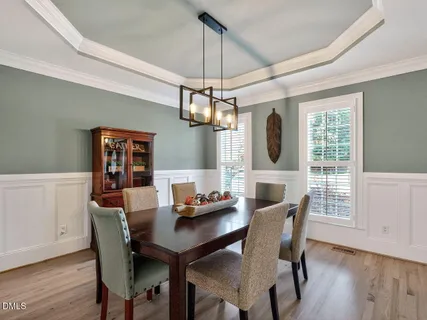 a dining room with furniture a chandelier and wooden floor