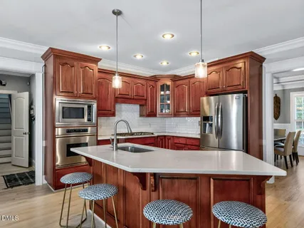 a kitchen with stainless steel appliances granite countertop a sink refrigerator and microwave