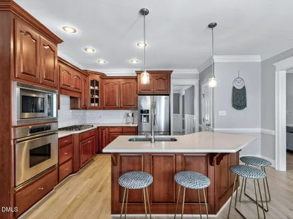 a kitchen with stainless steel appliances granite countertop a kitchen island a stove a table and chairs