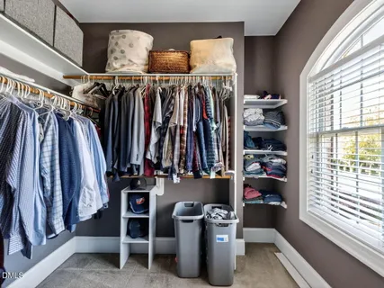 a view of walk in closet with clothes and shoes