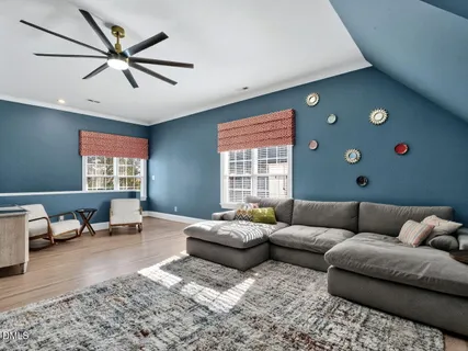a living room with furniture ceiling fan and a window